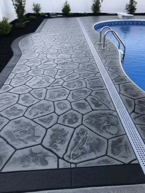 Photo d'une plage de piscine en béton imprimé gris avec caniveau de drainage