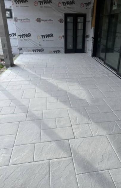Photo d'une terrasse en béton imprimé clair, motif pierre, sur un chantier en cours