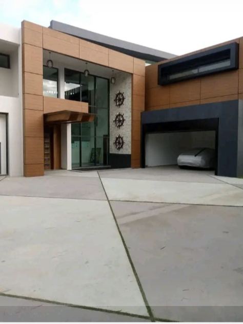 Photo de l'entrée d'une villa à façade composite bois et anthracite, avec auvent