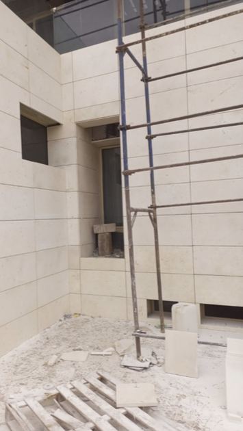 Photo de chantier : pose de panneaux composites en pierre naturelle sur une façade