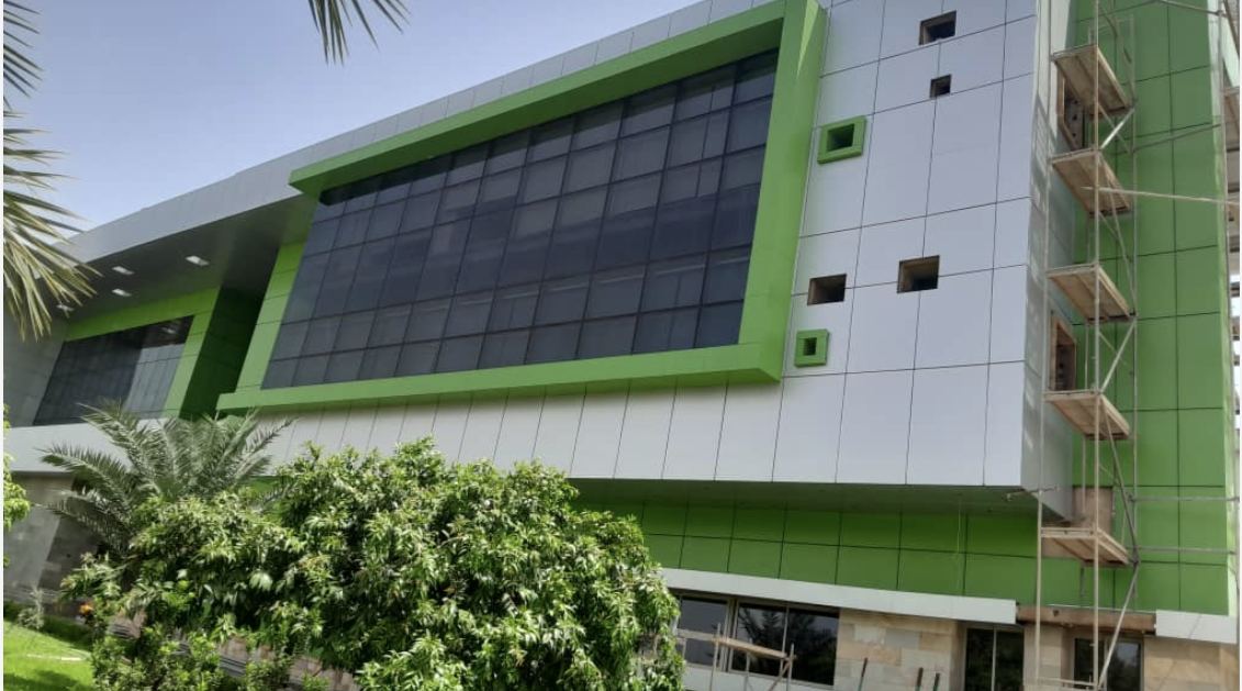 Photo de chantier : façade en panneaux composites aluminium vert et blanc, échafaudage en place