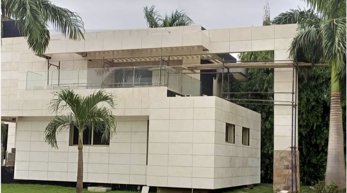 Photo d'une villa habillée de pierre naturelle claire, volumes en porte-à-faux et pergola