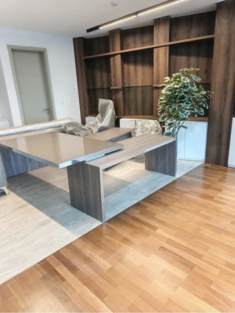 Photo d'un bureau au parquet clair, avec bibliothèque en bois sur mesure et table de réunion