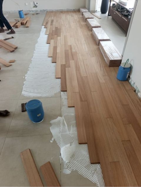 Photo de chantier : pose de lames de parquet massif dans une pièce en travaux